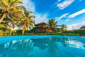 a villa with palm trees and a swimming pool at Casa Bella Barra Beach in Barra Grande