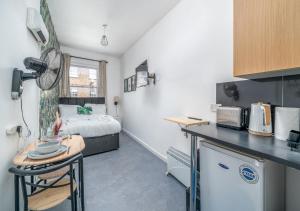 a room with a kitchen and a bedroom with a bed at Private Studio Unit in Chapel Market London in London