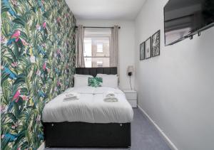 a bedroom with a bed with a floral wall at Private Studio Unit in Chapel Market London in London