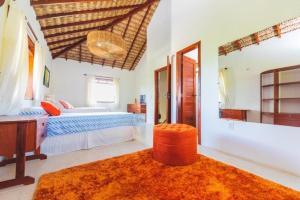 a bedroom with two beds and a desk and a mirror at Casa Bella Barra Beach in Barra Grande