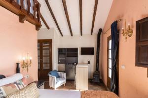 Zimmer mit einem Bett und einem Wohnzimmer in der Unterkunft Posada Morisca Charming Hotel Boutique in Frigiliana