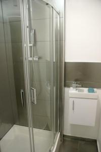 a bathroom with a glass shower and a sink at Luxury and serviced 3 bed house - Hampstead Garden in London