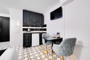 a kitchen with black cabinets and a table and chairs at Portist Hotel in Istanbul