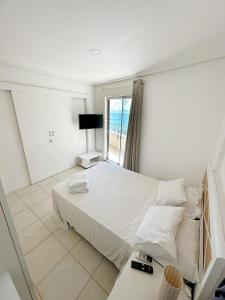um quarto branco com uma cama e uma janela em Residence Vespucci em Natal