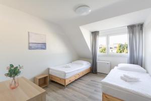 um quarto branco com duas camas e uma mesa em T&K Apartments - 3 Room Apartment with Balcony em Essen