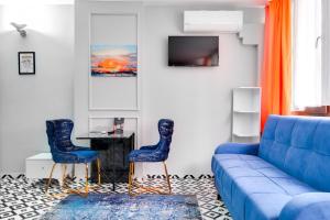 ein Wohnzimmer mit einem blauen Sofa und 2 Stühlen in der Unterkunft Portist Hotel in Istanbul