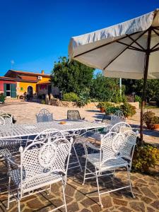 un tavolo e sedie con ombrellone su un patio di B&B Mare Calabria a Capo Colonna