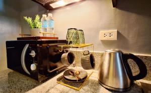 ELUDE Designer Suite Pasig - Prime Location في مانيلا: طاولة مطبخ مع محمصة وغلاية شاي