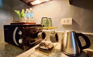 a kitchen counter with a toaster and a tea kettle at ELUDE Designer Suite Pasig - Prime Location in Manila +11 photos