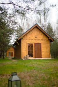ein kleines Holzhaus inmitten eines Feldes in der Unterkunft Ajurweda na Jurze Agroturystyka 