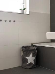 uma casa de banho com um caixote do lixo com uma estrela em Ferienwohnung ´´Hafenkante´´ direkt am See em Grossräschen