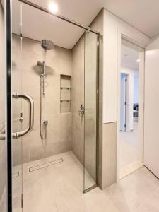 een douche met een glazen deur in de badkamer bij Dar Vacation - Bright and Charming 1 BR Apartment in Dubai