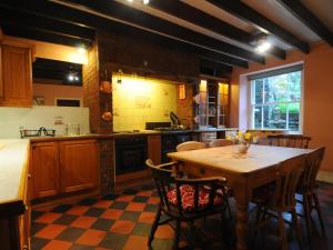 a kitchen with a wooden table and a dining room at Frondeg Nanternis in Llanllwchaiarn