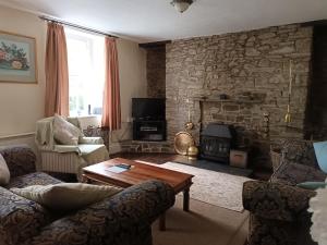 a living room with a stone wall at Frondeg Nanternis in Llanllwchaiarn