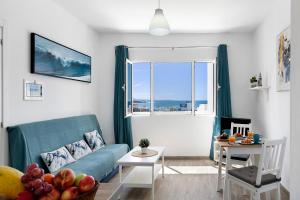 a living room with a blue couch and a window at Viviendas El Pescador - Vela in El Golfo