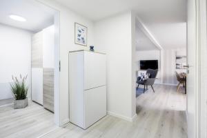 Un pasillo blanco con una puerta corredera que conduce a un comedor en geräumiger Ferienbungalow 70 QM I überdachte Terrasse I 2 Schlafzimmer I Strandnah, en Joachimsthal