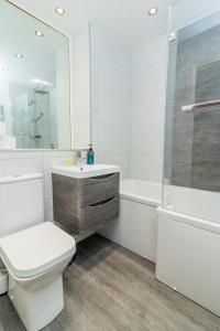 łazienka z toaletą, umywalką i wanną w obiekcie Belfast Quarters: 9th floor Gem! w mieście Belfast