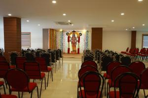 an empty room with chairs and a statue in the background at Hotel Mangala Temple View in Guruvāyūr