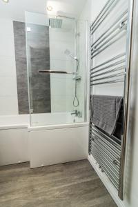 a bathroom with a shower and a bath tub at Belfast Quarters: 9th floor Gem! in Belfast