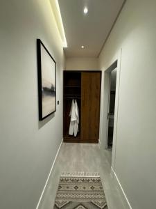 einen Flur mit einer Tür, an der ein Kleid hängt in der Unterkunft غرفة وصالة بتصميم فندقي in Riad