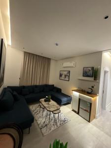 ein Wohnzimmer mit einem Sofa und einem Tisch in der Unterkunft غرفة وصالة بتصميم فندقي in Riad