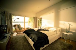 ein Schlafzimmer mit einem großen Bett und einem großen Fenster in der Unterkunft La Pinte du Vieux Manoir in Murten