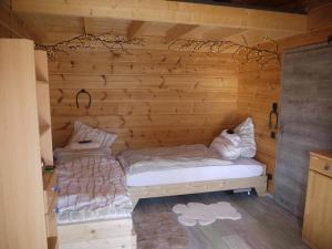 - une chambre avec 2 lits dans une cabane en bois dans l'établissement Blockhaus am Baumwipfelpfad, à Neuschönau