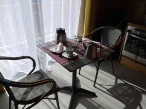 ノイシェーナウにあるBlockhaus am Baumwipfelpfadのテーブル(椅子2脚付)、お茶セット