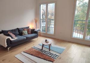 un soggiorno con un divano e un tavolo di Charming and Secure Fully-Equipped Apartment Close to Paris a Saint-Cloud