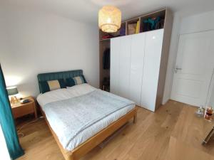 una camera con letto e armadio bianco di Charming and Secure Fully-Equipped Apartment Close to Paris a Saint-Cloud