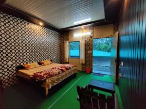 um quarto com uma cama num quarto com pisos verdes em Narayan valley resrot & hotel Sonparyag em Trijugi Nārāyan