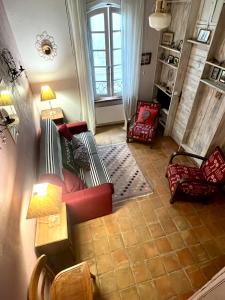 a living room with a red couch and a window at à St Rémy Petite maison au coeur du village in Saint-Rémy-de-Provence