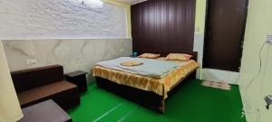 um quarto com uma cama e um piso verde em Narayan valley resrot & hotel Sonparyag em Trijugi Nārāyan