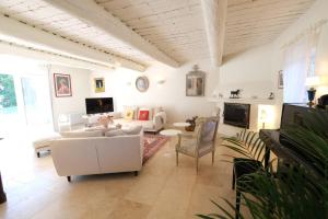 uma sala de estar com mobiliário branco e um sofá em LS2-433 MUSETO Typique mas provençal avec piscine privée, magnifique vue, située à lagnes, proche de l’isle sur la sorgue, pour 8 personnes em Lagnes