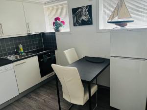 a kitchen with a table and chairs and a refrigerator at A Cozy Place To Stay Over in Tysvær