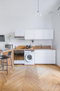 uma cozinha com armários brancos e uma máquina de lavar roupa em Studio Fêtes napoléoniennes Villa Marie Celine em Vichy