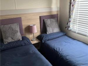 due letti uno accanto all'altro in una camera da letto di The willerby whitetower Caernarfon a Llanwnda