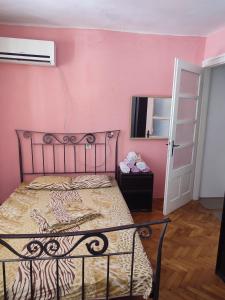 a bedroom with a bed and a pink wall at Apartment Filip in Vrbnik