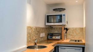 a kitchen with a sink and a tv on the wall at Homestead in Port Isaac