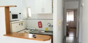 a small kitchen with a sink and a microwave at Exelente Departamento in La Plata