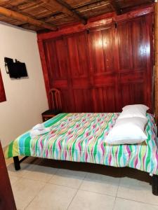 Bett in einem holzvertäfelten Zimmer in der Unterkunft CARRIQUI in Calarcá