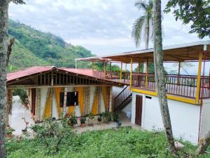 ein Haus mit einem Balkon und Palmen in der Unterkunft CARRIQUI in Calarcá