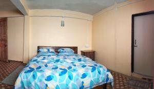 Sunrise في دارجيلنغ: غرفة نوم بسرير ازرق وبيض مع مخدات زرقاء