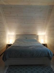 sypialnia z łóżkiem i dwoma lampkami na dwóch stołach w obiekcie "Morze Spokoju" domki letniskowe w Darłówku