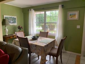 Cozy Cottage near Beaches and Downtown Sarasota في ساراسوتا: غرفة طعام مع طاولة وكراسي ونافذة