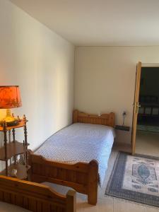 1 dormitorio con cama, lámpara y TV en Manousos Guest House en Heraclión