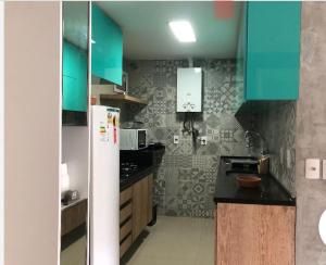 a kitchen with green cabinets and a black counter top at Apartamento Na Praia - VG FUn residence in Fortaleza
