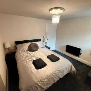 a bedroom with a large bed with two towels on it at Kirkcudbright Holiday Apartments - Apartment A in Kirkcudbright