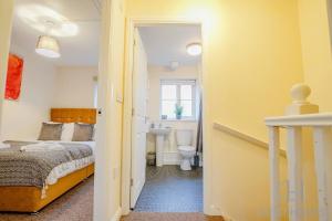 a bedroom with a bed and a bathroom with a sink at Blackthorn in Bury Saint Edmunds