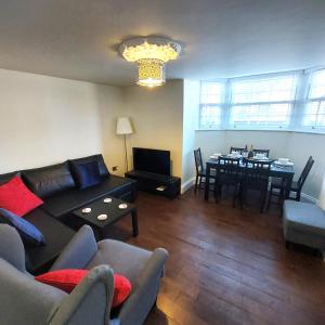 a living room with a couch and a dining room at Kirkcudbright Holiday Apartments - Apartment A in Kirkcudbright
